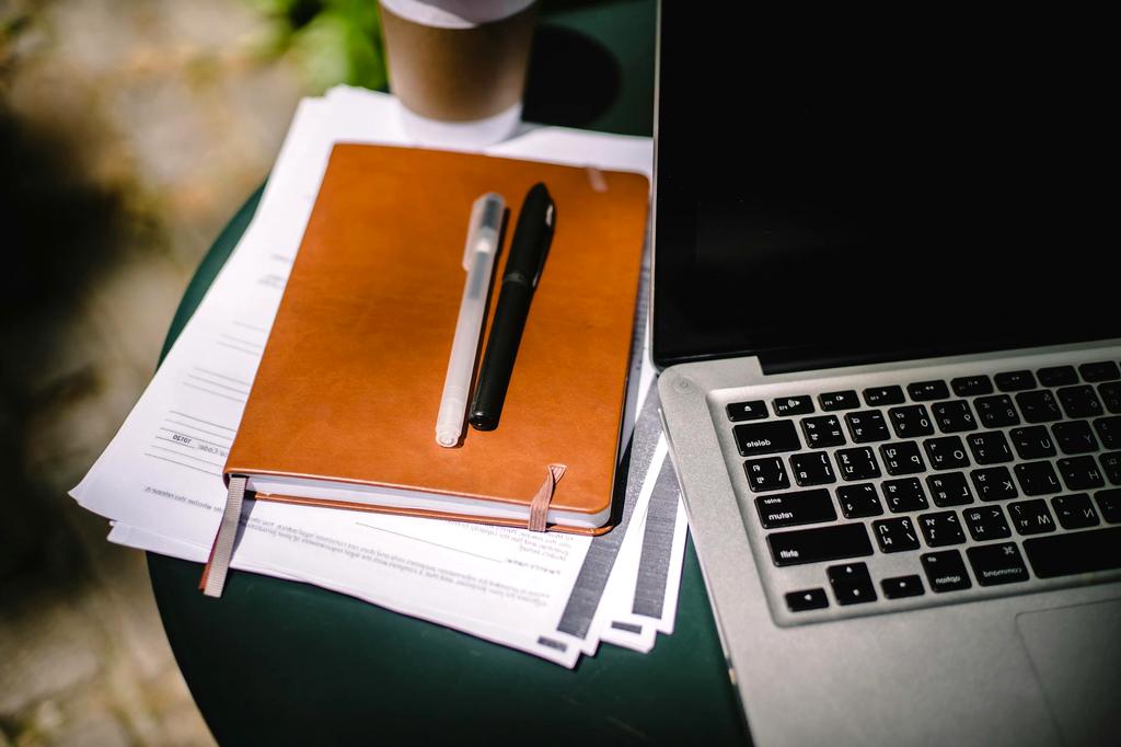 Person organizing digital files on laptop with notes nearby